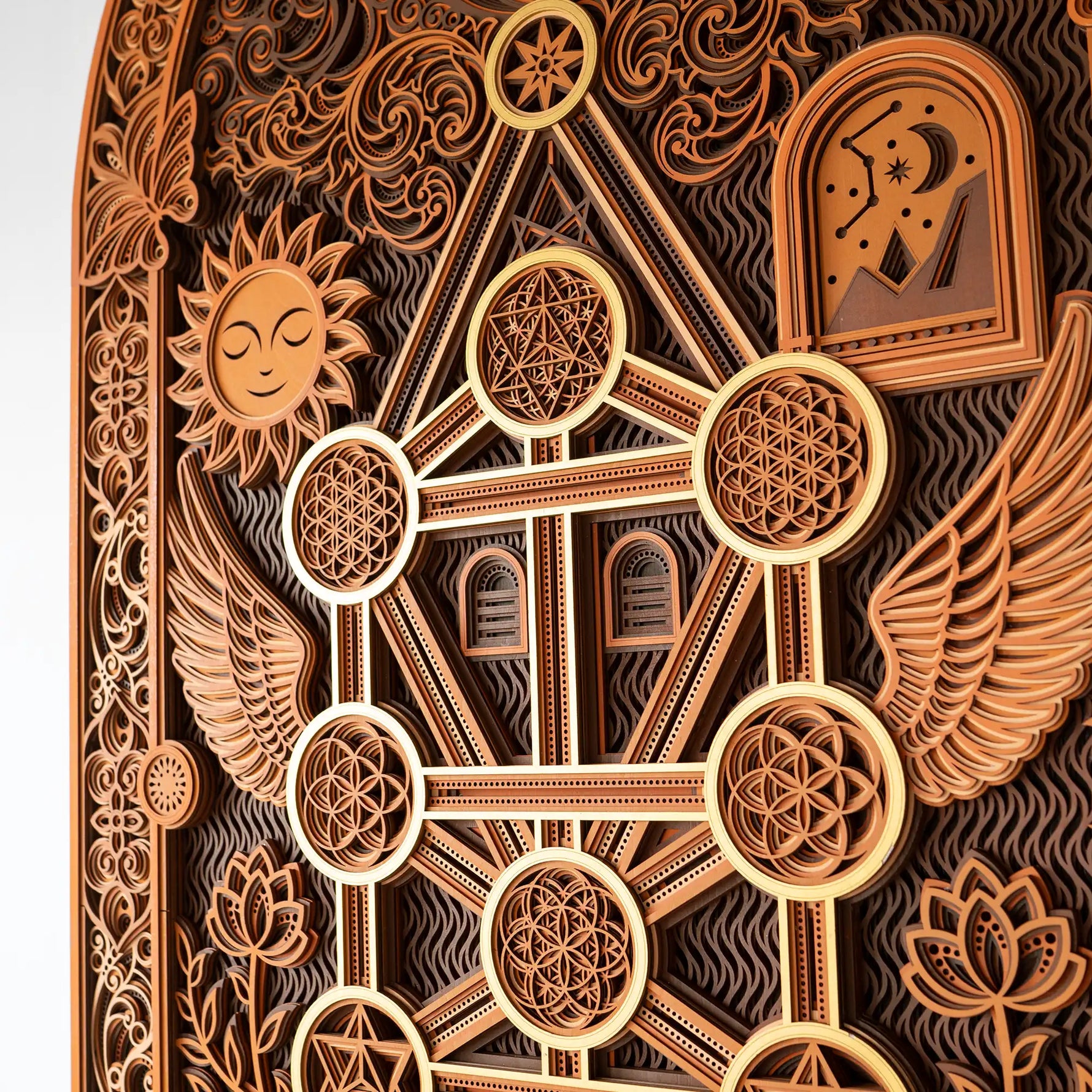 Decorative wooden panel with intricate carvings including a sun, moon, and geometric patterns.
