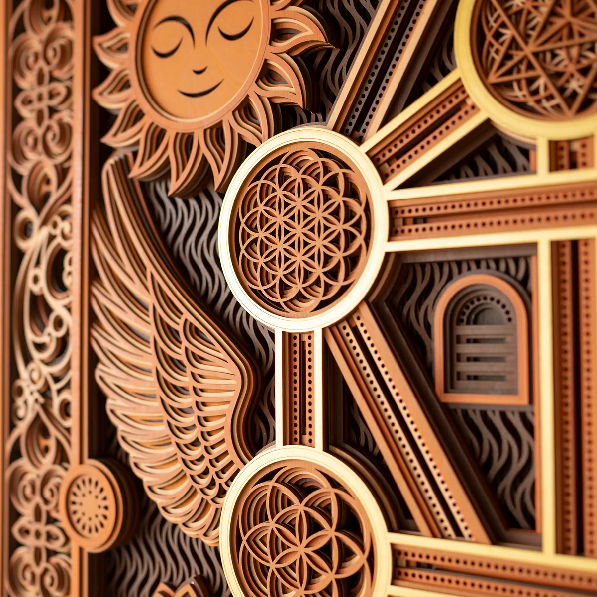 Decorative wooden design with intricate patterns and a sun-like figure.